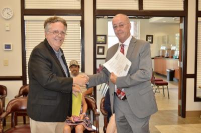 Mayor Ed Jarvis receives the deed to the property from John Whitlock